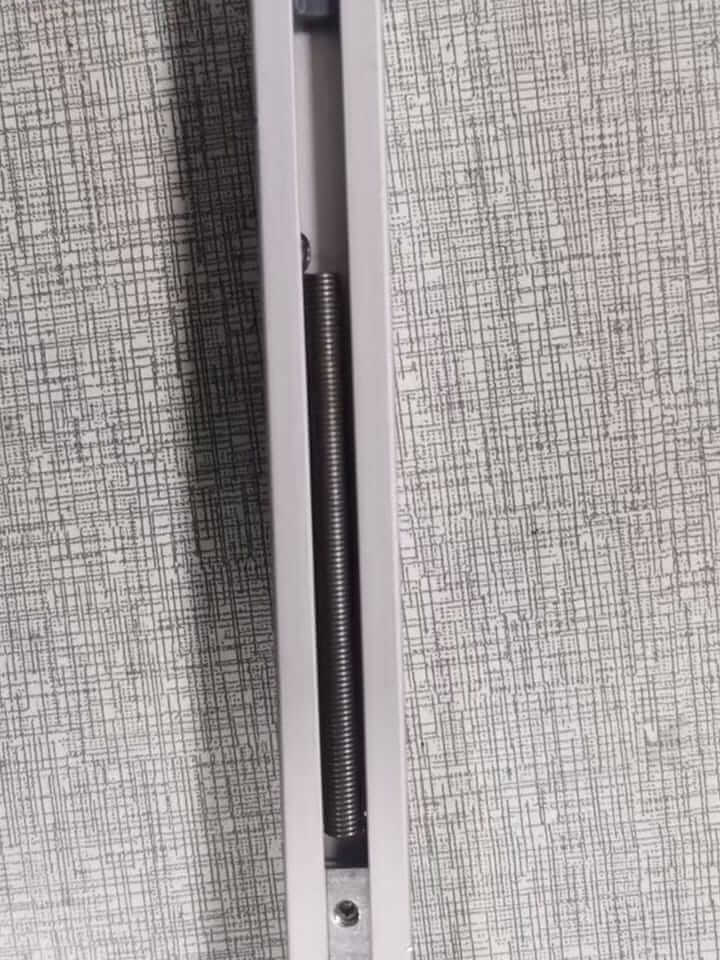 Close-up of custom extension spring installed in the curtain rail track, finished with anti-rust oil and spin-dry