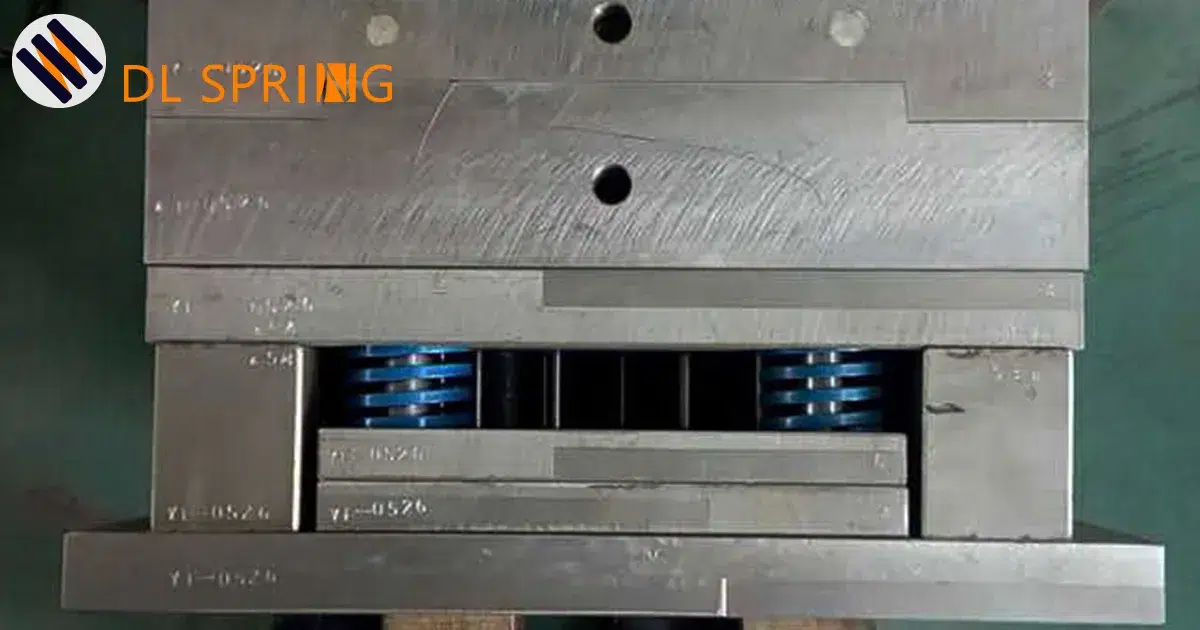 Blue JIS standard mold spring installed in injection mold showing YI-HSZH marking and coating