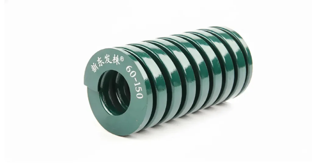 New SHINDONGBAL 60×150 green die spring showing proper coil spacing and surface finish. This JIS B5012 SH series heavy load spring has 150mm free length with maximum safe compression of 36mm (24%). Premium quality chrome-silicon steel construction for stamping dies and molds.