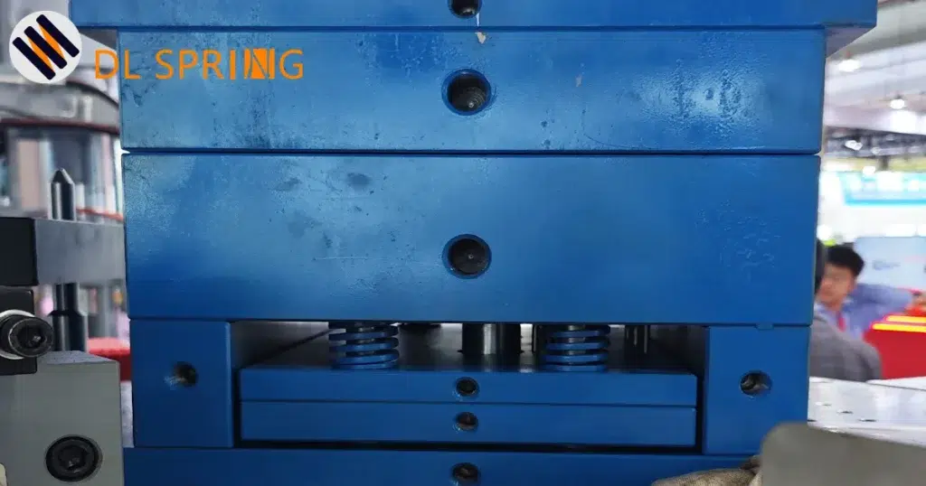 Blue die springs installed in injection mold base assembly showing proper spring pocket design and guidance system for optimal ejector pin return performance