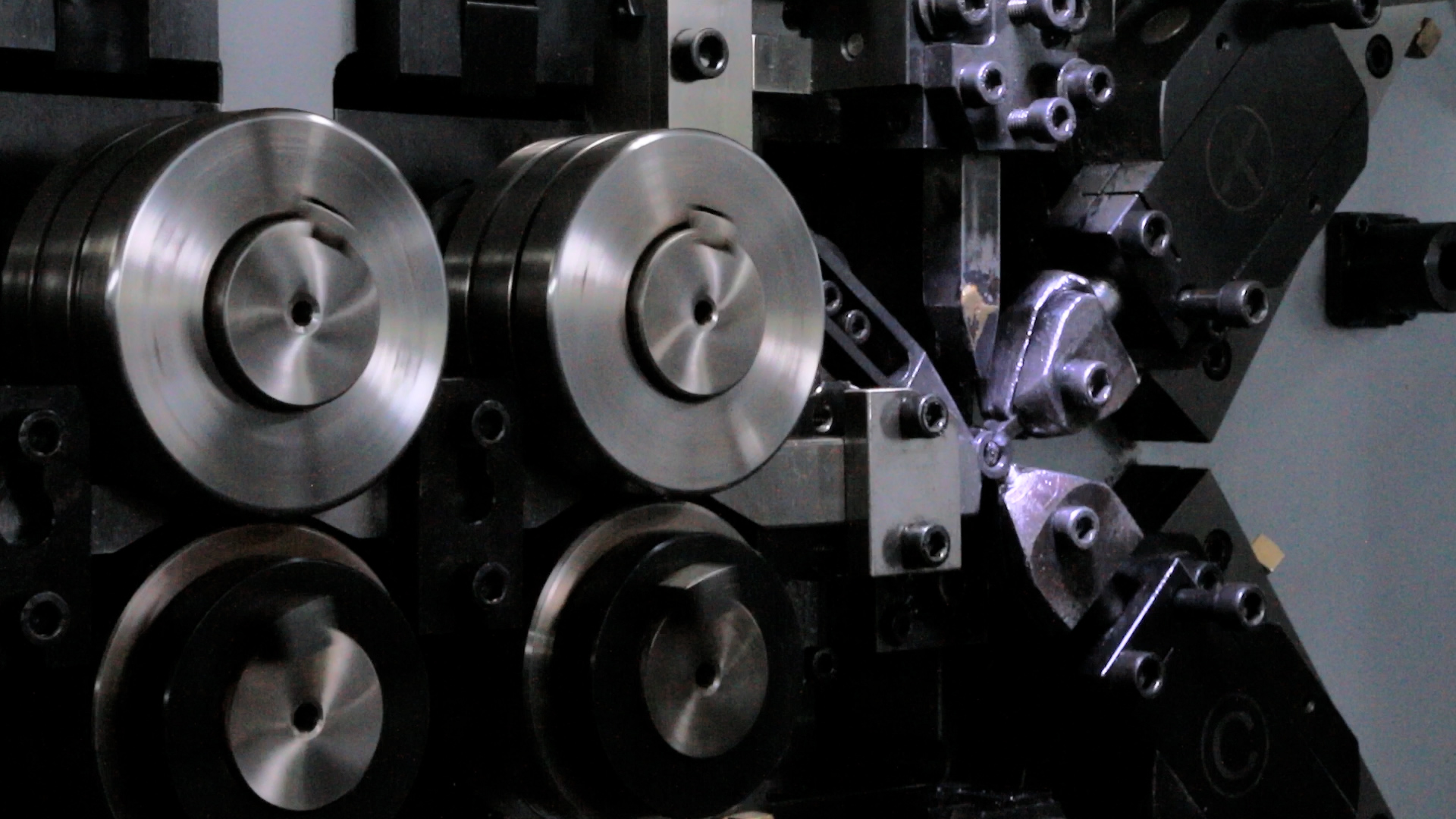 Feed rollers and front forming area during 65Mn round-wire spring coiling
